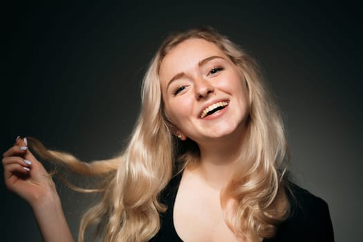 young girl blonde on a dark background.