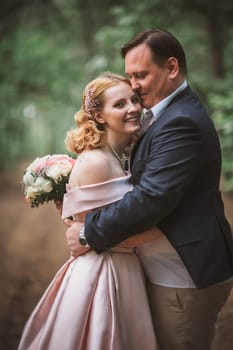 bride and groom kissing in the summer forest.