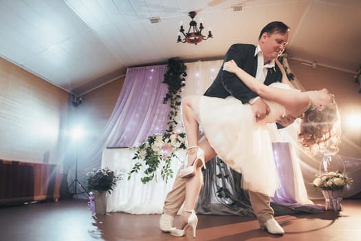 bride and groom first dancing on background a restaurant.