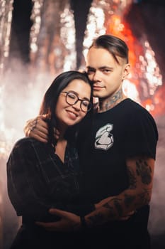 Couple in fashionable clothes on a shiny background.