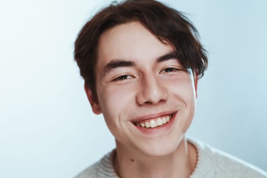 portrait of a teenager brunette guy in a studio.