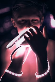 Portrait man Strip Light LED tape on dark color background.