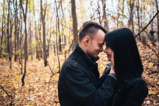 portrait of a young woman and a man walking in the autumn forest.
