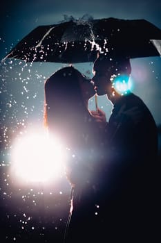 young man and woman under an umbrella and rain.