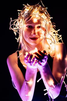 portrait of a girl with a garland on black background.
