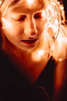 portrait of a girl with a garland on black background.
