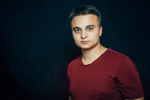 portrait of a young man on a dark background.