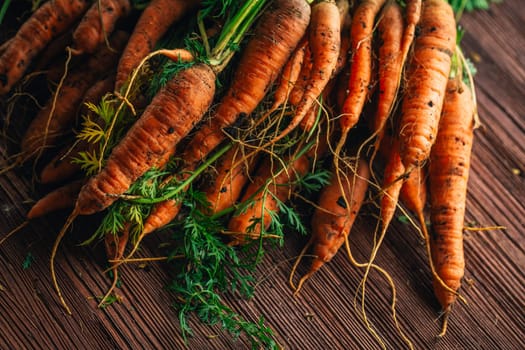 Fresh carrots from the garden close-up on a wooden background.