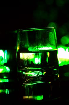 colored lighting of glasses in the night club bar.