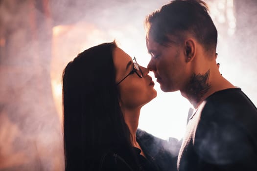 Couple in fashionable clothes on a shiny background.