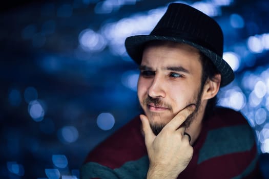 portrait of a guy in a hat on a blurred background.