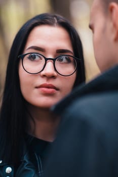 portrait of a young woman and a man walking in the autumn forest.