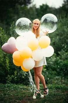 young girl with balloons on nature background.