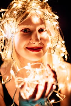 portrait of a girl with a garland on black background.