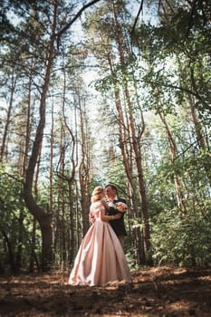 bride and groom on the background of trees and woods in full growth.