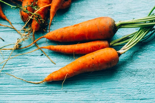 lot of carrots on a wooden background.