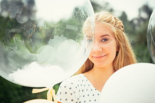 portrait of young girl with balloons on nature background.