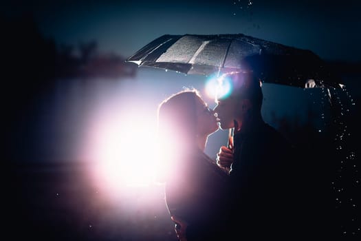 young man and woman under an umbrella and rain.