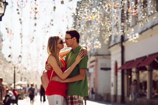 girl and guy on the background of the alley of garlands.