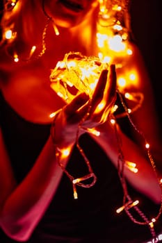 portrait of a girl with a garland on black background.