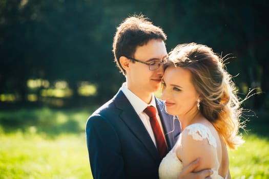 bride and groom embracing on nature background.