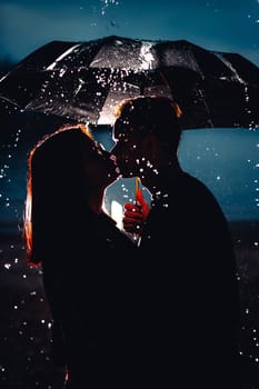 young man and woman under an umbrella and rain.