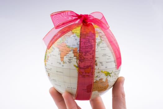 Globe tied with red ribbon on a white background