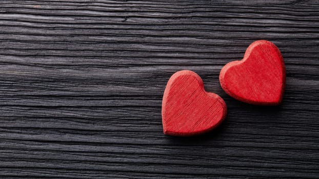 Two decorative hearts on a dark wooden background with copy space. top view. Valentine's Day card. Design element for romantic greeting card, wedding invitation