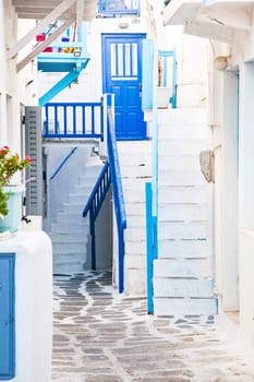 traditional narrow street in Mykonos with blue doors and white walls