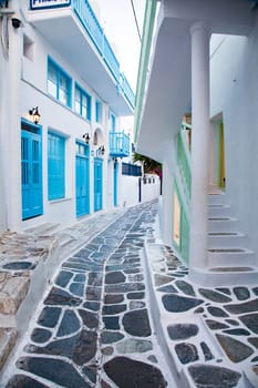 traditional narrow street in Mykonos with blue doors and white walls