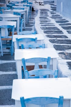 traditional narrow street in Mykonos with blue doors and white walls