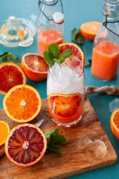 Cold cocktail with fresh bloodoranges and mint leaves