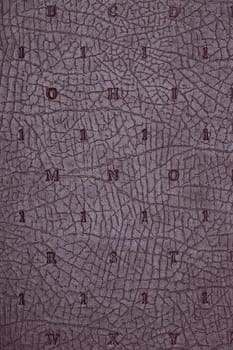 Leather background texture. Purple imitation leather book cover with embossed letters and numbers. High resolution image or macro.