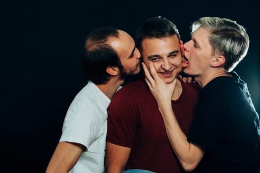 three guys are gay on dark background.