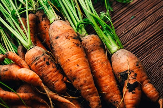 Fresh carrots close-up on a wooden background.