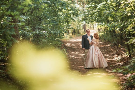 bride and groom dancing in the forest background and sunlight.