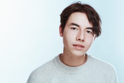 portrait of a teenager brunette guy in a studio.