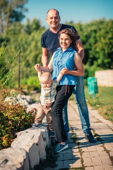 Happy family with baby son on nature background.