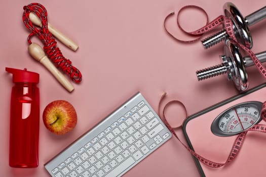 Female fitness still life. Sport accessories, scales, computer keyboard and mouse on pink background. Mockup. Planning of diet and trainings. Top view, copy space. Healthy lifestyle concept. Slimming
