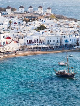 panoramic view of the Mykonos town harbor with famous windmills from the above hills on a sunny summer day, Mykonos, Cyclades, Greece