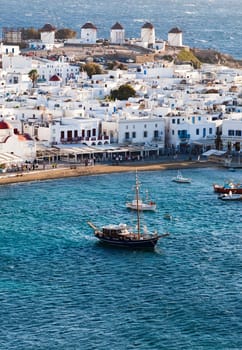 panoramic view of the Mykonos town harbor with famous windmills from the above hills on a sunny summer day, Mykonos, Cyclades, Greece