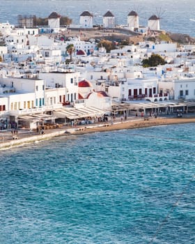 panoramic view of the Mykonos town harbor with famous windmills from the above hills on a sunny summer day, Mykonos, Cyclades, Greece