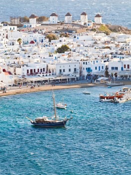 panoramic view of the Mykonos town harbor with famous windmills from the above hills on a sunny summer day, Mykonos, Cyclades, Greece