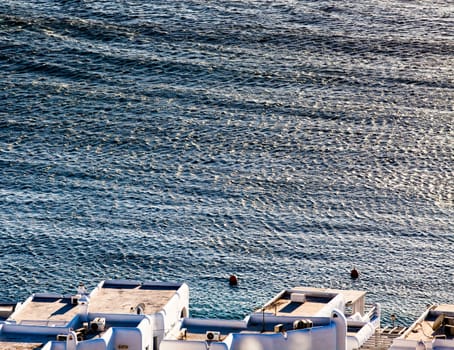 panoramic view of the Mykonos town harbor with famous windmills from the above hills on a sunny summer day, Mykonos, Cyclades, Greece