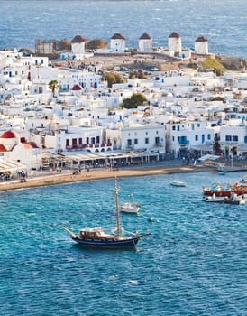 panoramic view of the Mykonos town harbor with famous windmills from the above hills on a sunny summer day, Mykonos, Cyclades, Greece