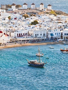 panoramic view of the Mykonos town harbor with famous windmills from the above hills on a sunny summer day, Mykonos, Cyclades, Greece
