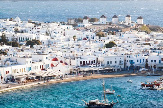 panoramic view of the Mykonos town harbor with famous windmills from the above hills on a sunny summer day, Mykonos, Cyclades, Greece