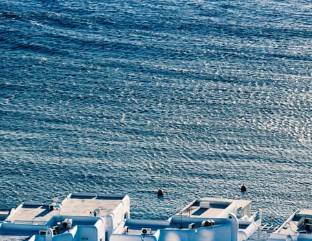 panoramic view of the Mykonos town harbor with famous windmills from the above hills on a sunny summer day, Mykonos, Cyclades, Greece