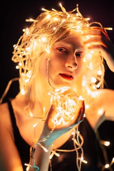 portrait of a girl with a garland on black background.