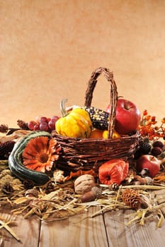 Pumpkins,apples,nuts,berries,corn and cereals with basket on old weathered wooden boards